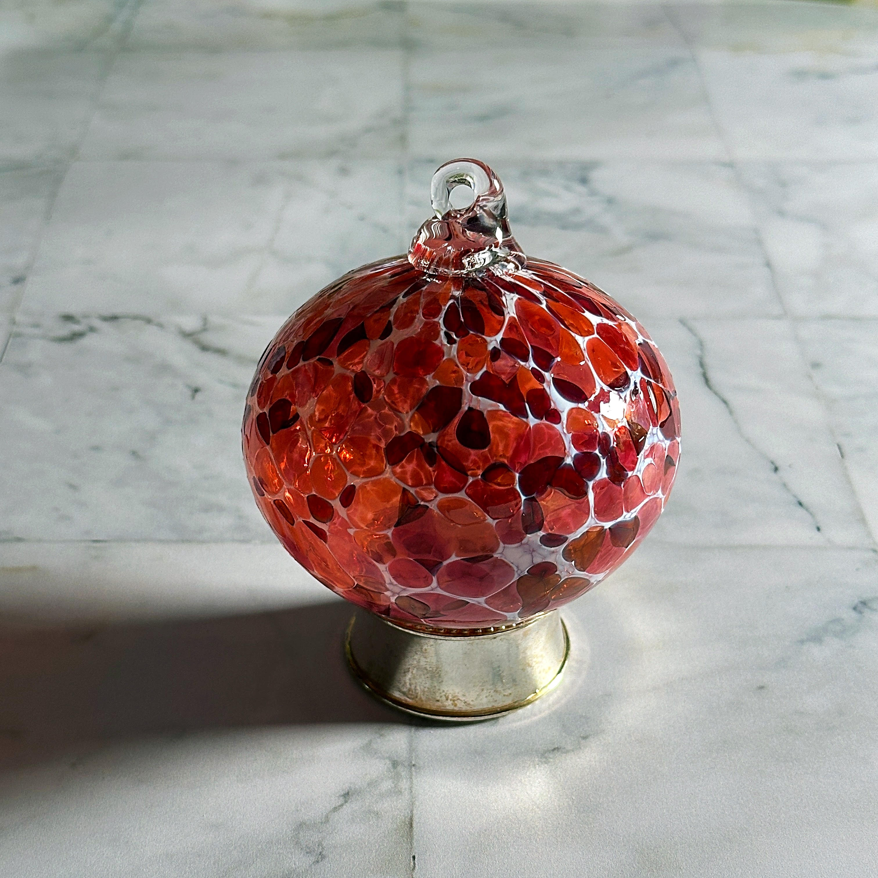 red round hand-blown glass ornament on display