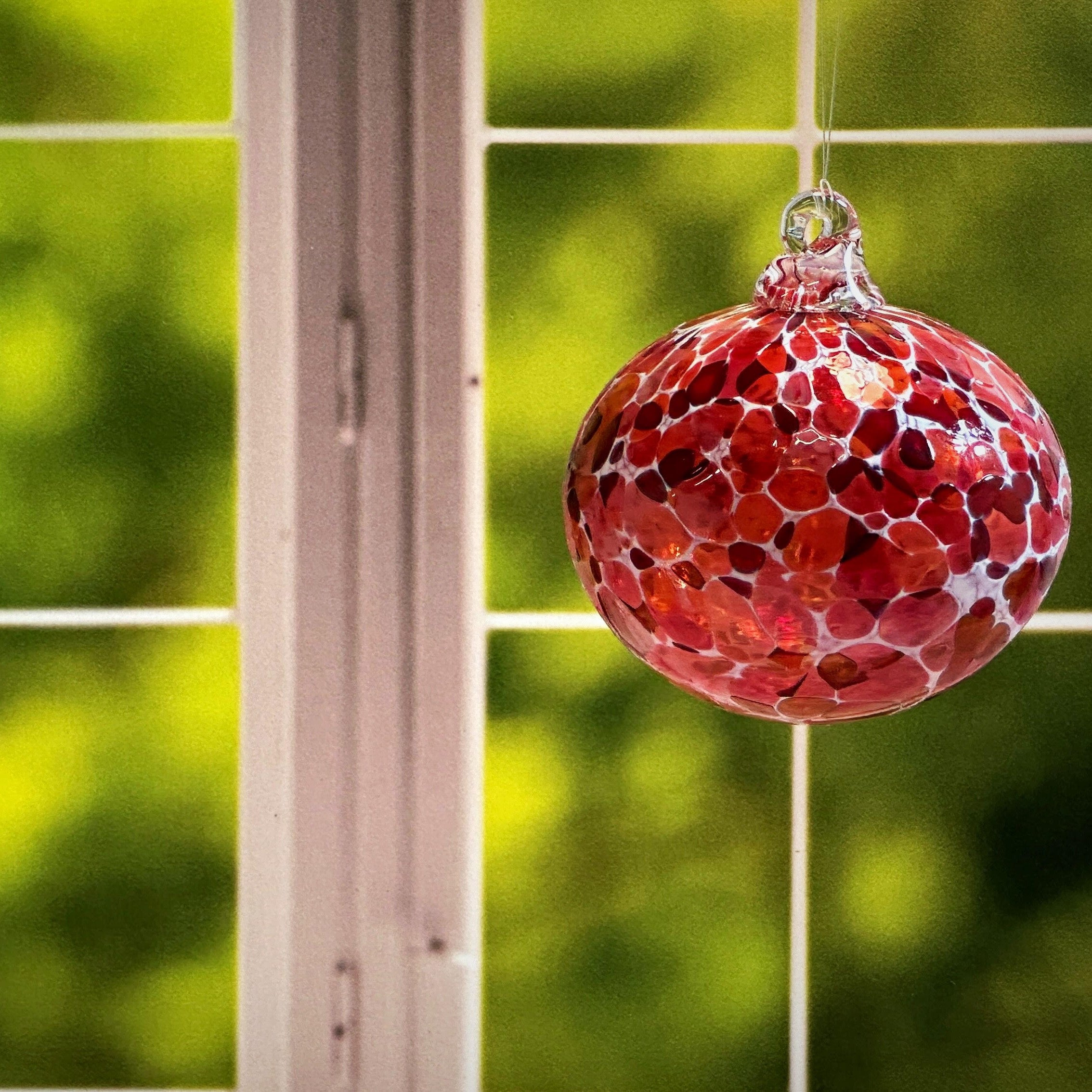 round hand-blown glass ornament in a window