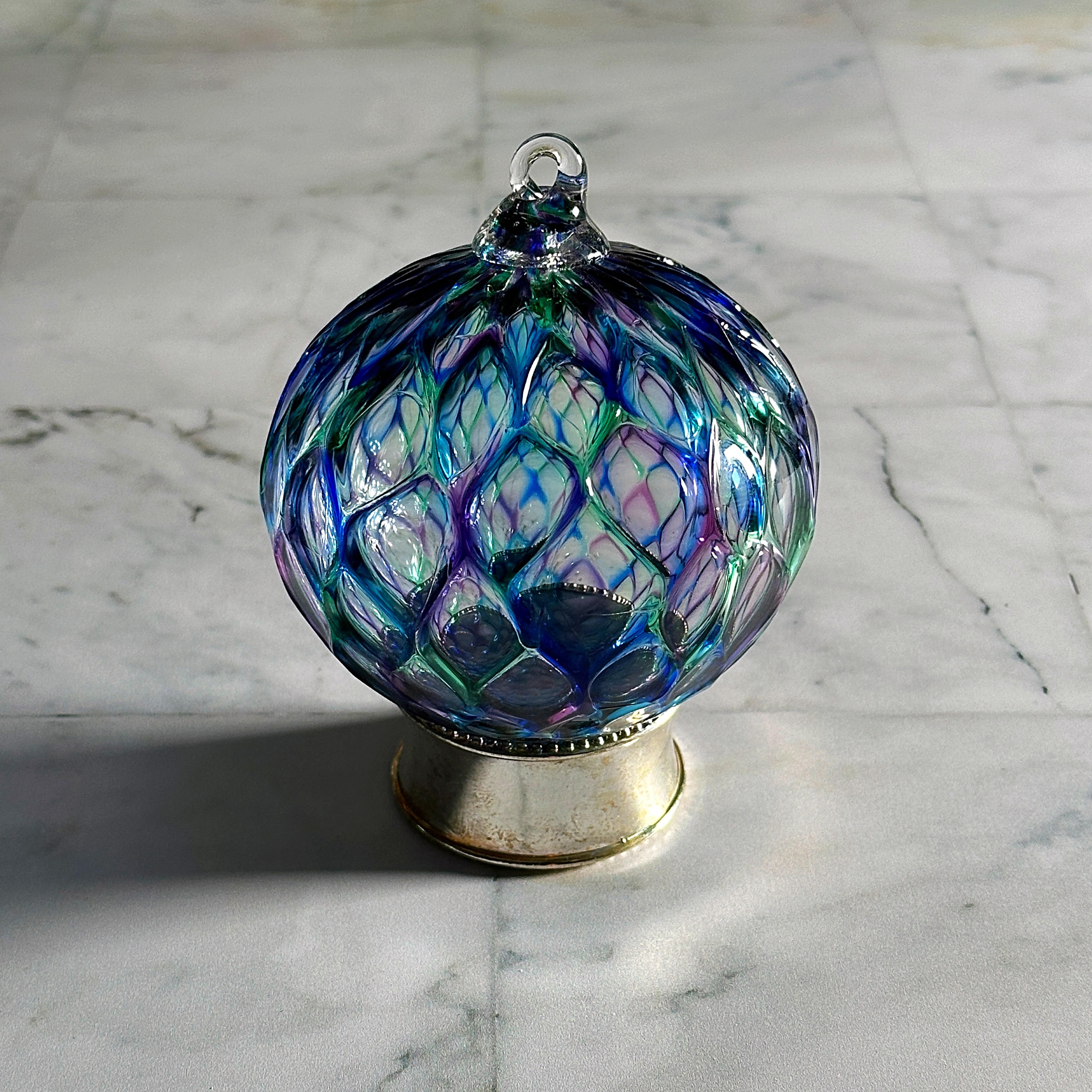 blue, green and purple hand-blown diamond carved glass ornament on display