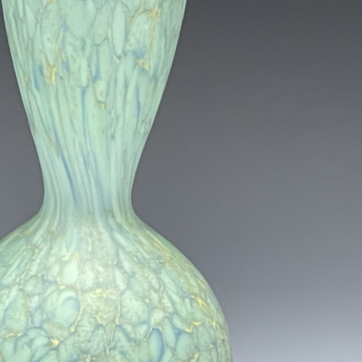 detail of celadon blown glass bottle