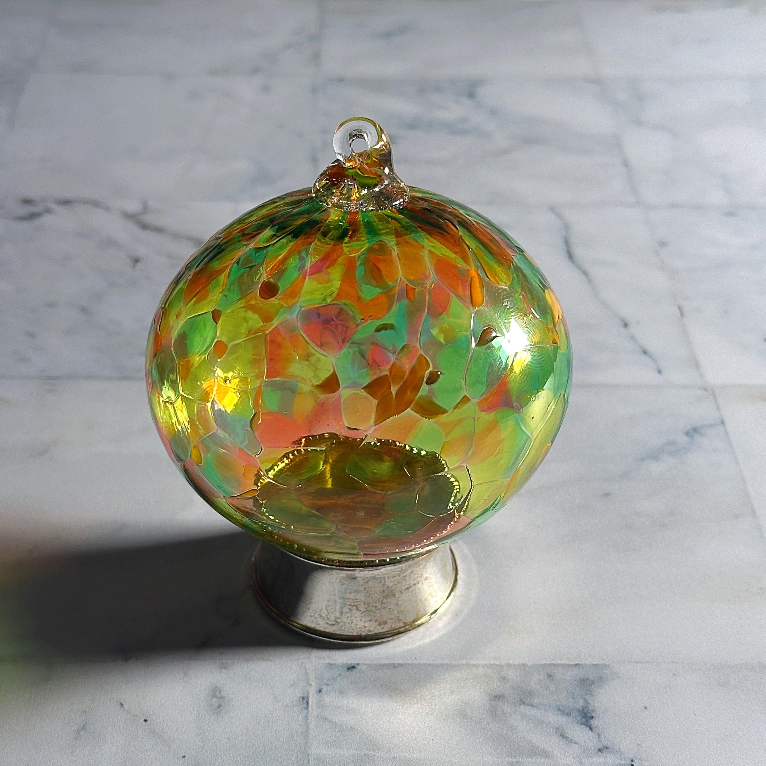 multicolored round hand-blown glass ornament on display