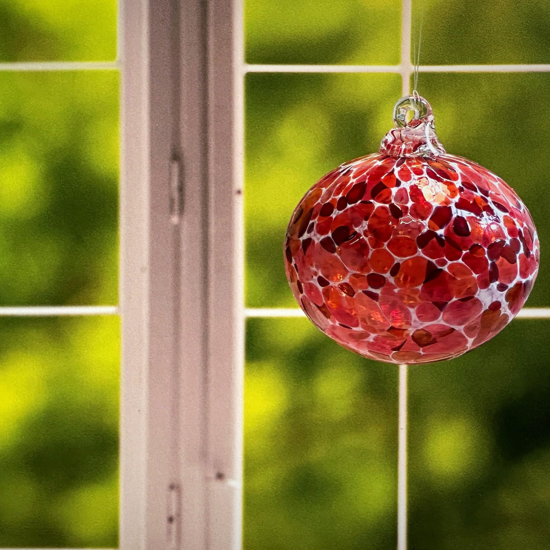 round hand-blown glass Ornament in a window