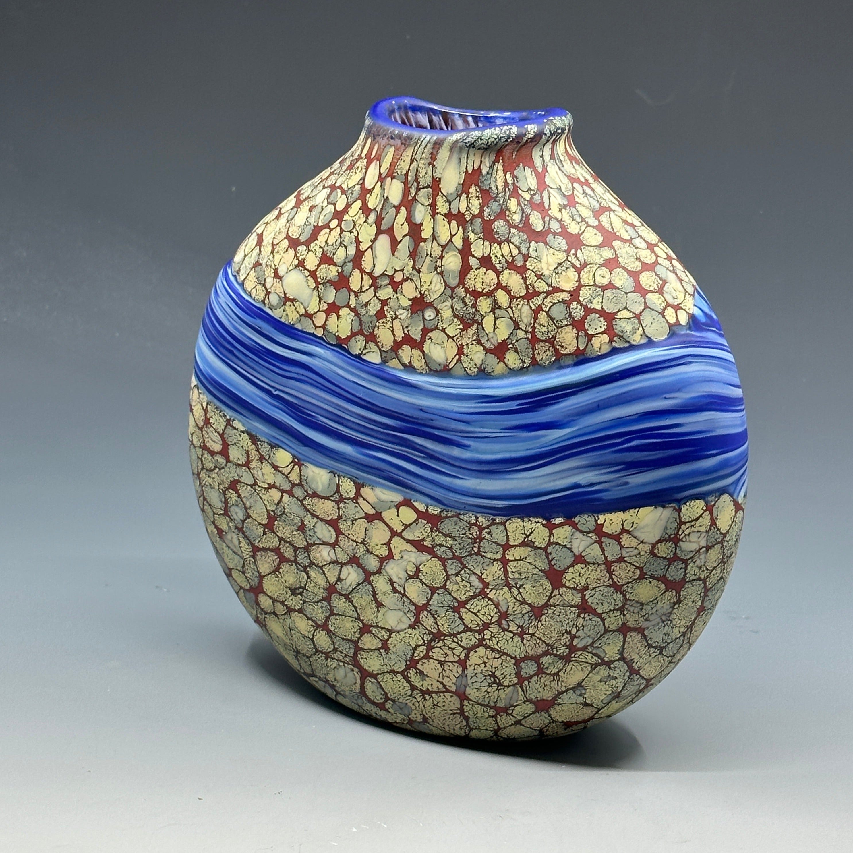 side view of sandy strata vase with blue stripe